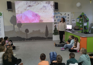 Uczniowie oglądają film edukacyjny pt. „Wędrówka torebki folowej”.