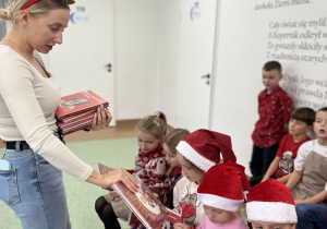 Nauczyciela rozdaje książki uczniom
