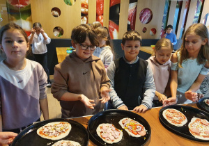 dzieci przyrzadzają pizzę