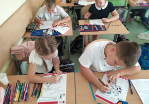 Dzieci rozwiązują karty pracy