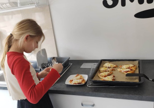 uczennica smaruje sosem czosnkowym trójkąt