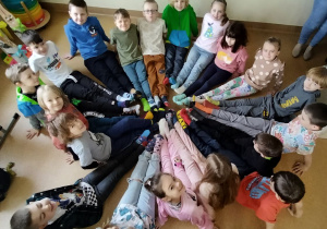 uczniowie siedząc w kole prezentują kolorowe skarpety