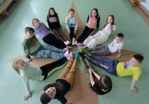 uczniowie siedząc w kole prezentują kolorowe skarpety