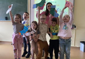 uczniowie z nauczycielem prezentują prace plastyczne – kolorowe skarpety