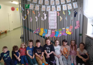 uczniowie na tle dekoracji prezentują kolorowe skarpety