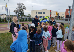 funkcjonariusz policji rozmawia z uczniami