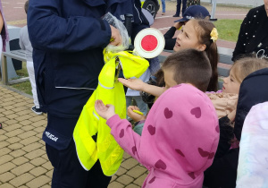 policjant rozdaje uczniom odblaski