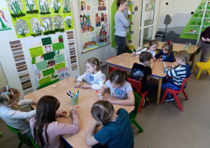 Przedszkolaki tworzą kolorowe magnesy na lodówkę