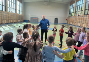 Przedszkolaki na sali gimnastycznej, kończą zajęcia okrzykiem