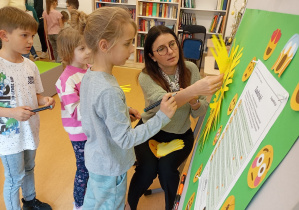 Uczniowie tworzą słoneczko z odrysowanych i podpisanych dłoni