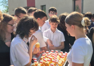 Uczennica rozdaje uczniom babeczki