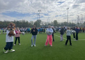 Dziewczynki wraz z Kubusiem prowadzą rozgrzewkę dla uczestników turnieju