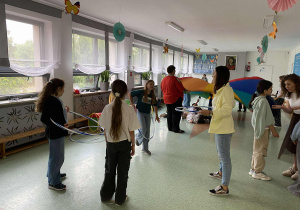 uczniowie z opiekunem wykonują ćwiczenie - wyzwanie z użyciem hula-hop