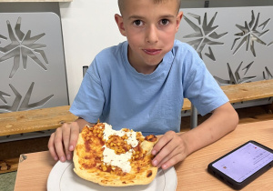 Chłopiec je pizze
