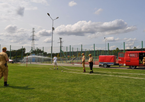 uczeń leje wodą do celu