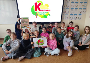 uczniowie klasy 2a pozujący z plakatami programu „Kubusiowi Przyjaciele Natury”