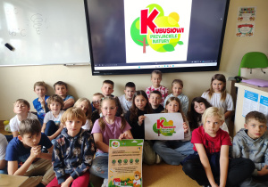 uczniowie klasy 2b pozujący z plakatami programu „Kubusiowi Przyjaciele Natury”