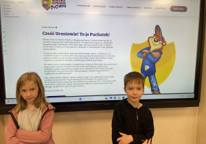 uczniowie klasy pierwszej pozujący na tle projektu „Akademii Bezpiecznego Puchatka”