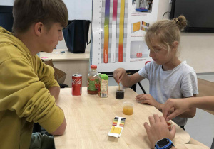 4 -dzieci wykonują doświadczenie - badanie pH roztworów za pomocą wskaźników papierowych