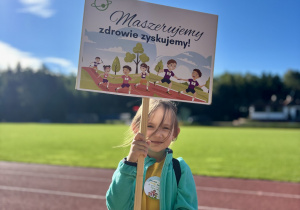 Uczennica z transparentem promującym aktywnośc