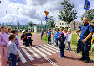 uczniowie słuchają, jak bezpiecznie poruszać się po przejściu dla pieszych