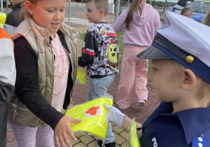 mali policjanci rozdają wszystkim uczestnikom spotkania prezenty – odblaskowe kamizelki