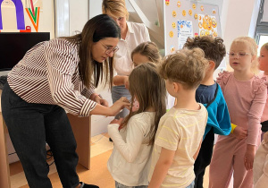Uczniowie odbierają śmieszne naklejki z uśmiechniętymi buziami