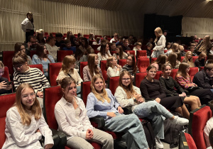 Uczniowie zajmują miejsca na widowni.