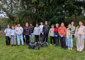 uczniowie klasy 6b w plenerze podczas sprzątania najbliższej okolicy