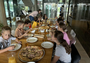 Uczniowie jedzą pizzę