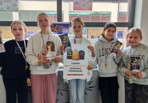 uczennice prezentują plakat i ulotki na temat przemocy