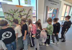 uczniowie przyczepiają listki do „Drzewka przyjaźni”