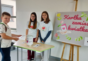 uczeń podczas kupowania kartki – cegiełki