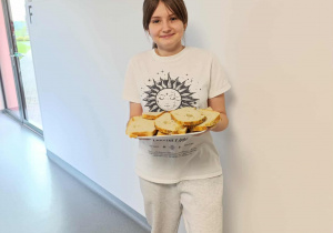 Uczennica częstuje chlebem