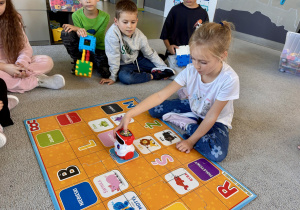 Uczennica programuje robota, aby dotarł na zielone pole.