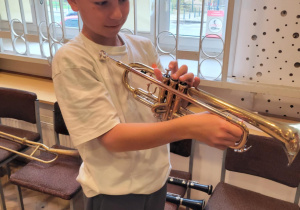 Chłopcy oglądają trąbkę.