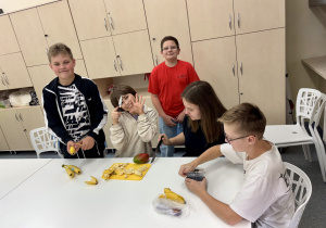 Uczniowie kroją owoce.