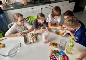 Uczniowie przygotowują ciasto bananowe.