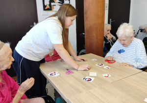 wolontariusz pomaga podopiecznym w wykonaniu pracy techniczno-plastycznej