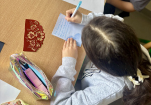 Uczennice redagują życzenia urodzinowe.