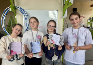 Uczennica prezentuję efekty swojej pracy nad kartką urodzinową.