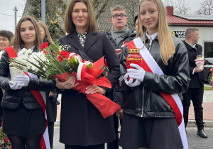 Pani Dyrektor wraz z asystą przygotowują się do złożenia kwiatów pod pomnikiem.