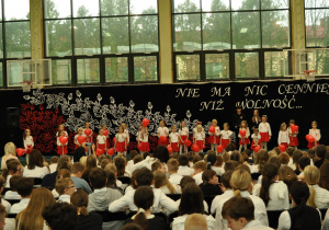 Uczniowie obserwują tańczące koleżanki z klasy 1.