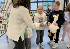 Pani nauczycielka częstuje dzieci cukierkami