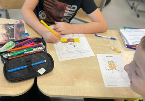 Chłopcy rozwiązują łamigłówki i rebusy matematyczne.