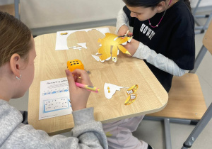 Dziewczynki pracują nad wspólnym projektem.