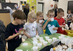 Uczniowie częstują się słodkim poczęstunkiem