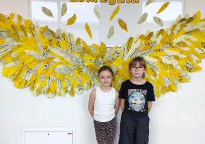 dziewczynki pozują na tle dekoracji „Życzliwość uskrzydla”