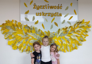 dziewczynki pozują na tle dekoracji „Życzliwość uskrzydla”