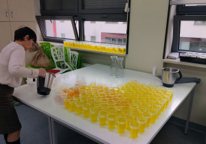 nauczyciel przygotowuje żółte - owocowe galaretki na finał Tygodnia Życzliwości